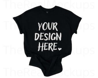 Puede incluir: Camiseta negra con mangas enrolladas. La camiseta presenta el texto "YOUR DESIGN HERE" en blanco, con letras manuscritas, con un pequeño símbolo de corazón. Esta camiseta es una maqueta, ideal para mostrar diseños personalizados.