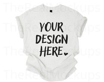 May include: A light gray t-shirt with rolled-up sleeves. The front of the shirt features the text "YOUR DESIGN HERE" in bold black letters, with a small heart symbol below the text. The shirt is a mockup for design placement.