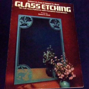May include: A book titled "Glass Etching" by Robert A. Capp & Robert G. Bush. The book features 46 full-size patterns with complete instructions. The cover shows a mirror with a floral design and a vase with pink flowers.