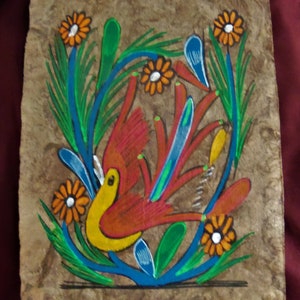 May include: Hand-painted artwork on textured paper. A vibrant bird with red, yellow, and blue accents is surrounded by orange flowers and green foliage. The artwork has a folk art style and is set against a brown background.