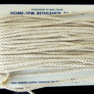 May include: A spool of white cotton rope, purchased by mail from Home-Sew, Bethlehem, PA. The spool is labeled with a free sewing supply catalog offer.