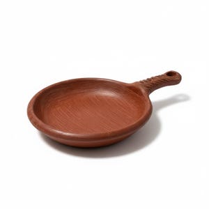 May include: A small, round, terracotta-colored ceramic pan with a handle. The handle has a textured, twisted design and a hole at the end. The pan has a shallow bowl shape, perfect for serving small portions.