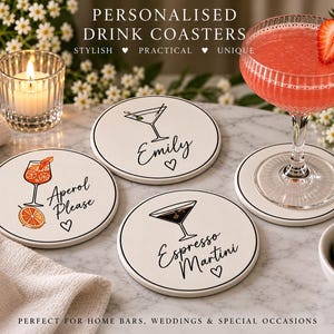 May include: Three round white ceramic drink coasters with black rims. One features an orange cocktail graphic and the text "Aperol Please", one shows a martini glass and "Emily", and one displays a cocktail glass and "Espresso Martini".