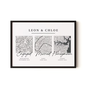 May include: A framed wall art print featuring the text LEON & CHLOE above three square black and white city maps. Below the maps, the text reads Engaged Manchester November 2018, Married Paris June 2020, and Honeymoon Sydney August 2024.