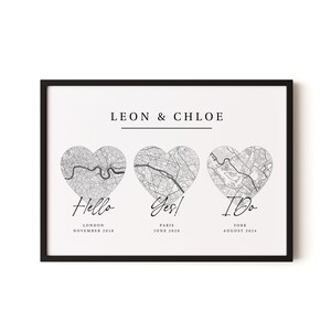 May include: A framed print featuring the text LEON & CHLOE above three heart-shaped city maps of London, Paris, and York. Below each map are the words Hello, Yes!, and I Do, followed by the dates November 2018, June 2020, and August 2024.