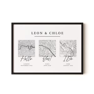 May include: A framed print featuring the names LEON & CHLOE above three square black and white city maps of London, Paris, and York. Below each map are the words Hello, Yes!, and I Do, followed by the city name and date in black text.