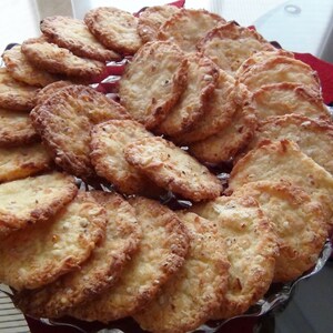 Puede incluir: Un plato de galletas doradas, crujientes y ligeramente dulces. Las galletas est&aacute;n dispuestas en c&iacute;rculo, con las galletas m&aacute;s grandes en el centro y las galletas m&aacute;s peque&ntilde;as alrededor de los bordes.