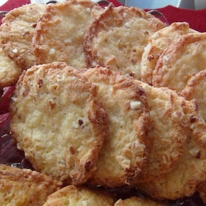 Puede incluir: Un plato de galletas doradas con una textura ligeramente crujiente. Las galletas est&aacute;n dispuestas en un patr&oacute;n circular y parecen estar hechas con una combinaci&oacute;n de mantequilla, az&uacute;car y harina.