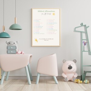 May include: A framed print with the text "Biblical Affirmations for Little Hearts" hangs on a wall. The room features a pink table and chair set, a bear-shaped toy, and a giraffe-shaped shelf. The color scheme is soft pastel tones.