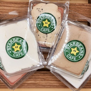 May include: Four clear plastic containers with lids, each containing a different coloured wax melt. The wax melts are labelled "Starbeans Cafe" with a green star logo.