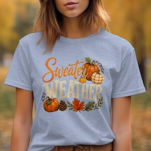 Gray t-shirt with "Sweater Weather" text and pumpkins, leaves, pinecone.