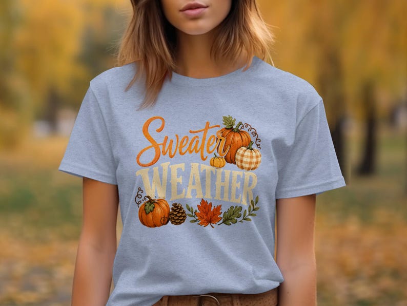 Gray t-shirt with "Sweater Weather" text and pumpkins, leaves, pinecone.