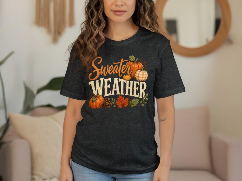 Dark t-shirt with "Sweater Weather" text featuring pumpkins and fall leaves.