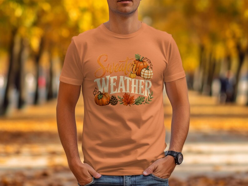 Orange t-shirt with "Sweater Weather" text and pumpkin, pinecone, and leaf graphic.
