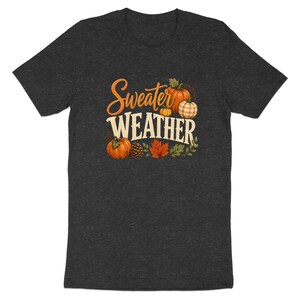 Dark grey t-shirt featuring "Sweater Weather" text with pumpkins and autumn leaves.
