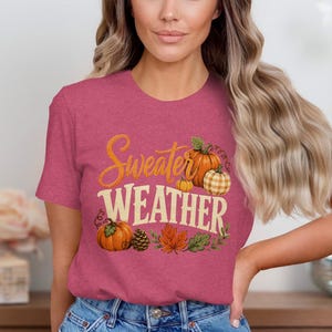 Pink t-shirt with "Sweater Weather" text and pumpkin graphic.