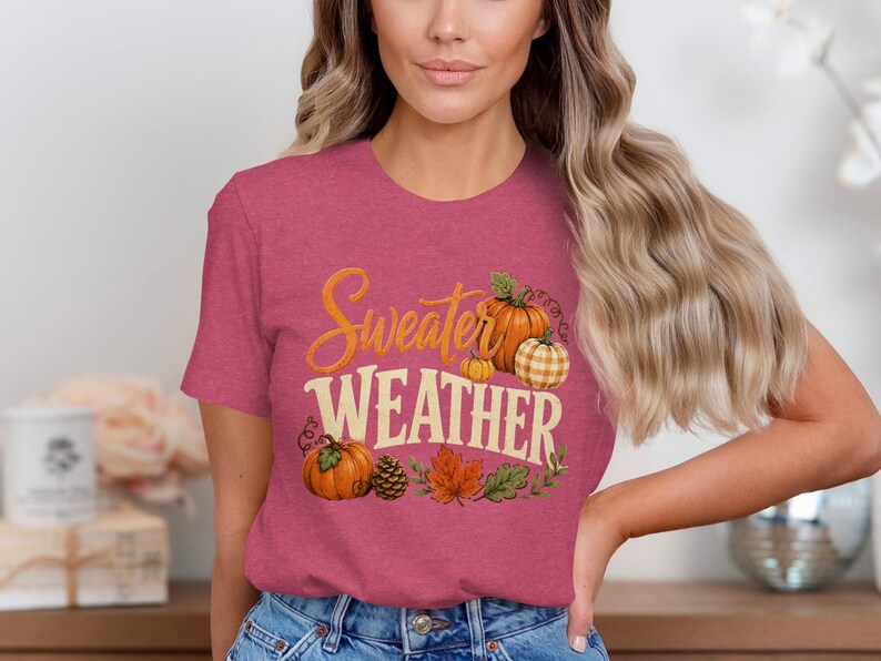 Pink t-shirt with "Sweater Weather" text and pumpkin graphic.