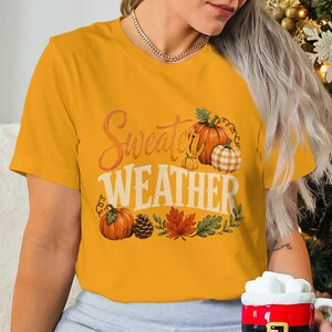Yellow t-shirt with "Sweater Weather" text and pumpkin autumn graphics.
