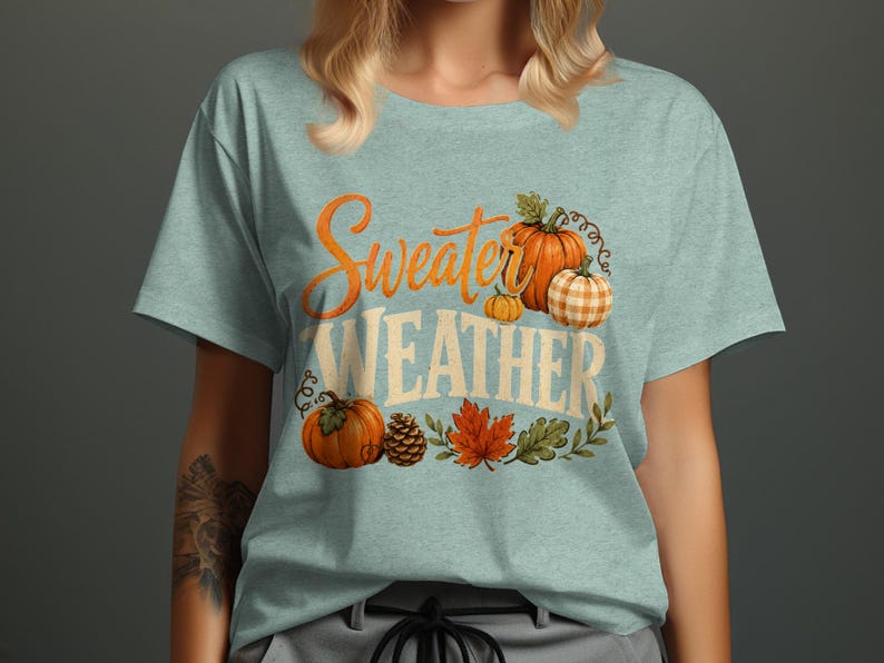 Light blue t-shirt with "Sweater Weather" text and pumpkins, leaves.