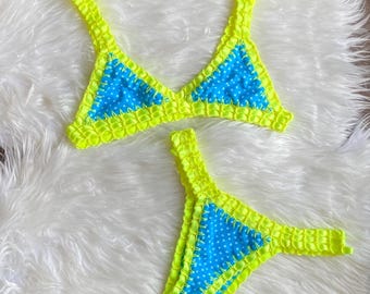 Blauwe gebreide bikini met witte en gele stippen.