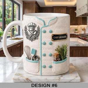 May include: White ceramic mug designed to resemble a chef's jacket, featuring a chef's hat emblem, utensils, and a nameplate that reads "CHEF LEONARD." The mug has light blue accents and decorative buttons. The bottom of the mug reads "DESIGN #6."