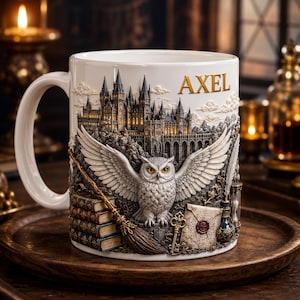 May include: A white ceramic mug featuring a raised, detailed relief of a castle, a large owl with spread wings, a stack of books, a broomstick, a key, a sealed envelope, and an hourglass. The name AXEL is printed in gold lettering at the top.