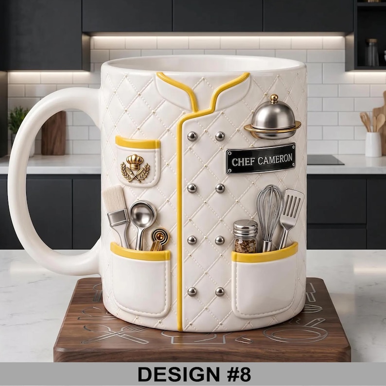 May include: White ceramic mug with a chef's coat design, featuring yellow trim and silver accents. The mug includes a nameplate that reads "CHEF CAMERON" and the text "DESIGN #8" at the bottom.