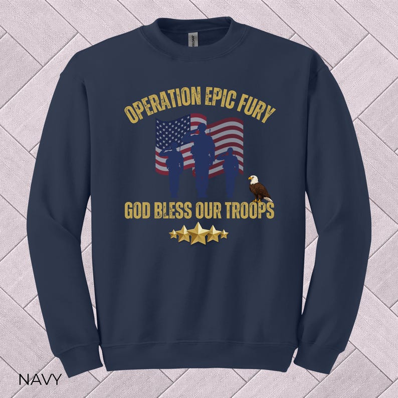 May include: Navy blue sweatshirt with the text "OPERATION EPIC FURY" and "GOD BLESS OUR TROOPS". The design includes an American flag, silhouettes of soldiers, an eagle, and gold stars. The word "NAVY" is at the bottom.