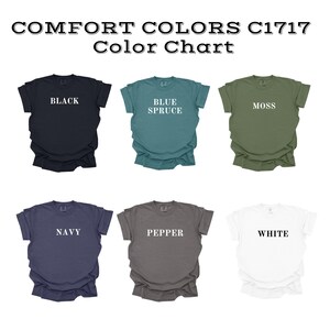 May include: Color chart featuring six t-shirts in various colors: black, blue spruce, moss, navy, pepper, and white. Each shirt displays its color name in white text. The text "COMFORT COLORS C1717 Color Chart" is at the top.