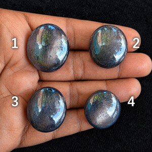 May include: Four round, polished dark blue gemstones with a smooth, reflective surface. Each stone is numbered 1 through 4 in white text. The stones exhibit a deep, dark blue hue with subtle internal inclusions and a high-gloss finish.