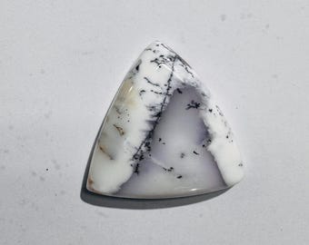 Cabochão de opala dendrítica polida para confecção de joias.
