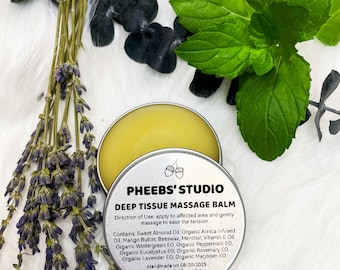 May include: A round, silver tin of "Deep Tissue Massage Balm" with a yellow balm inside. The label includes the brand name "PHEEBS' STUDIO" and a list of ingredients. The image also features sprigs of lavender and mint.