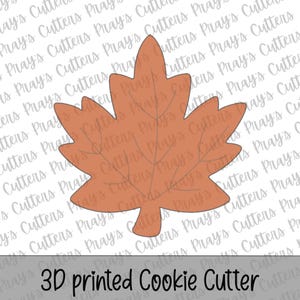 May include: A terracotta-colored 3D printed cookie cutter shaped like a maple leaf with embossed vein details. The object is centered against a repeating watermark background that reads Pray's Cutters, with the text 3D printed Cookie Cutter below.