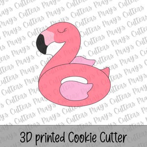 May include: A pink flamingo-shaped cookie cutter with a black beak tip and a closed eye detail. The design features a flamingo body integrated into a circular float shape. The text 3D printed Cookie Cutter is visible at the bottom.
