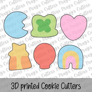 May include: A collection of 3D printed cookie cutters in various shapes, including a heart, shamrock, rainbow, and a Pac-Man-like shape. The cutters are in pastel colors and the text "3D printed Cookie Cutters" is at the bottom.