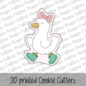 Può includere: Un tagliabiscotti stampato in 3D a forma di un'oca dei cartoni animati con stivali verde acqua e un fiocco rosa. L'oca ha un becco giallo e sta camminando. Il testo "3D printed Cookie Cutters" è in basso.