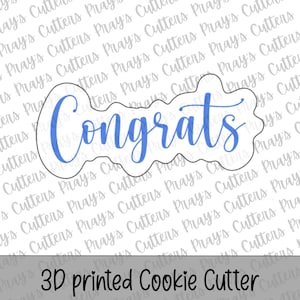 May include: A 3D printed cookie cutter in the shape of the word "Congrats" in a blue script font. The cutter has a wavy outline and the text "3D printed Cookie Cutter" is below the cutter.