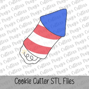 May include: A firework rocket cookie cutter with a blue conical top and a body featuring diagonal red and white stripes. The base of the rocket shows a black outline of a fuse with a small yellow starburst detail. The text reads Cookie Cutter STL Files.