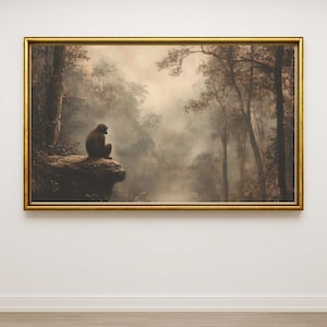 May include: A framed painting depicting a monkey sitting on a rock overlooking a misty forest. The artwork features a gold frame and a muted color palette of browns and greens, creating a serene and contemplative scene.