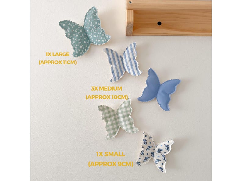 May include: A collection of fabric butterfly decorations in various sizes and patterns, including blue floral, striped, and solid blue designs. The largest butterfly is approximately 4.3 inches across. The image includes text indicating the size of each butterfly.