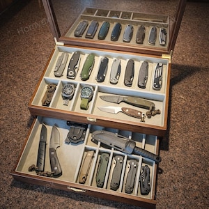 May include: A white ceramic mug with a black handle and the text "But First, Coffee" in a bold, black font. The mug is set against a blurred background, suggesting a cozy setting.