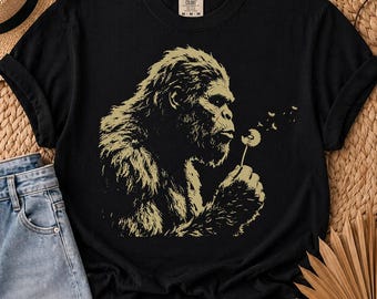 Camiseta de Bigfoot soplando un diente de león, arte vintage de Sasquatch, atuendo para amantes de la naturaleza.