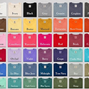 May include: A grid of forty-nine folded crew neck t-shirts in various solid colours, each labelled with its specific colour name including White, Ivory, Black, Gray, Granite, Graphite, Pepper, Espresso, Banana, Butter, Mustard, Terracotta, Burnt Orange, Yam, Blossom, Crunchberry, Watermelon, Heliconia, Red, Brick, Crimson, Chili, Orchid, Violet, Berry, Grape, Chalky Mint, Lagoon Blue, Flo Blue, Ice Blue, Blue Jean, Midnight, True Navy, Bay, Khaki, Island Reef, Seafoam, Light Green, Blue Spruce, Moss, Hemp, and Sage.