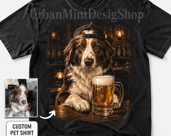 May include: A black short-sleeve t-shirt featuring a graphic of a brown and white dog wearing a baseball cap, sitting at a bar with a glass of beer. A small inset photo shows the original dog, and the text reads Custom Pet Shirt.
