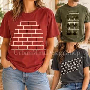 Könnte beinhalten: Drei kurzärmelige T-Shirts mit Rundhalsausschnitt in Rot, Olivgrün und Anthrazit. Jedes Shirt zeigt eine weiße Liniengrafik eines Ziegelsteinmusters. Das rote Shirt zeigt eine breite Pyramide, das grüne einen hohen Stapel und das graue eine Diagonale.