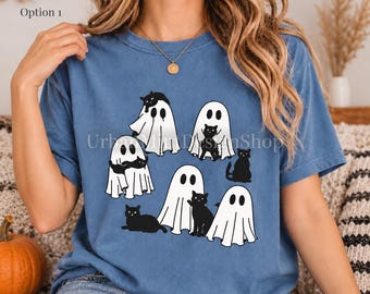 May include: A blue short-sleeve t-shirt featuring a graphic print of several white ghosts and black cats. The design shows ghosts draped in white sheets interacting with black cats in various poses. The text Option 1 is visible in the corner.