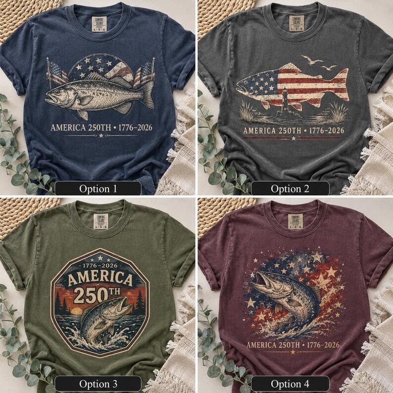 May include: Four short-sleeve t-shirts in navy, charcoal, olive, and maroon. Each features a graphic print with a fish, American flag elements, and the text AMERICA 250TH 1776-2026. The designs include various patriotic motifs like stars, stripes, and lighthouses.