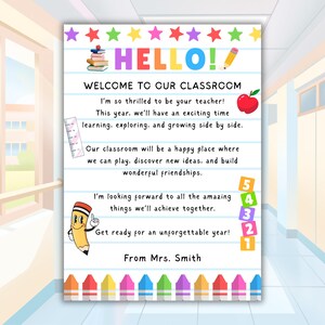 May include: A colorful classroom welcome sign with the word "HELLO!" in large, multi-colored letters. The sign includes text welcoming students, a red apple, a ruler, and a cartoon pencil. The bottom of the sign has a row of colorful crayons.