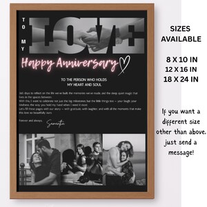 May include: A framed black and white print with the word "LOVE" and the text "Happy Anniversary." The print includes a photo of hands holding, and a message. Available sizes are 20.3 x 25.4 cm, 30.5 x 40.6 cm, and 45.7 x 61 cm.