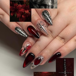 May include: A hand with long, dark red and silver nail art. The nails feature a variety of designs, including metallic accents, a sword, and a deep red, glossy finish. The image also includes a close-up of red flowers, armor, and a sword.